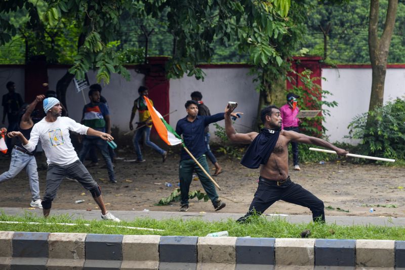 Protesters throw stones towards police while protesting against the rape and murder of a resident doctor at a government hospital earlier this month, in Kolkata, India, Tuesday, Aug. 27, 2024. (AP Photo/Bikas Das)