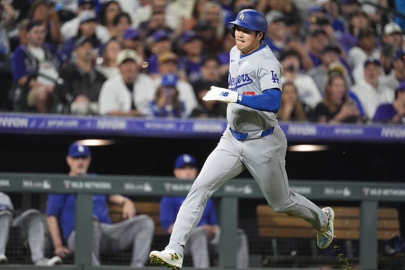 Los Angeles Dodgers' Shohei Ohtani scores on a double hit by Kevin Kiermaier off Colorado Rockies relief pitcher Luis Peralta in the eighth inning of a baseball game Friday, Sept. 27, 2024, in Denver. (AP Photo/David Zalubowski)