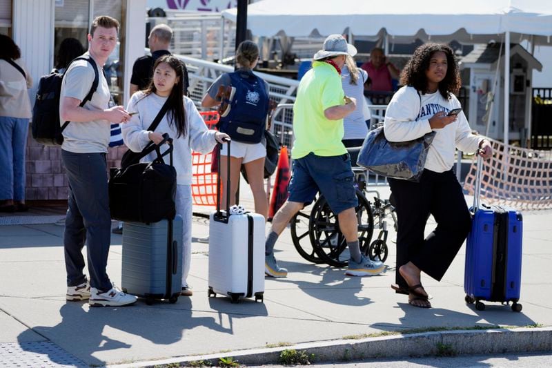 Travelers wait for ride shares after disembarking the ferry from Nantucket Island, Friday, Aug. 30, 2024, in Hyannis, Mass. (AP Photo/Michael Dwyer)