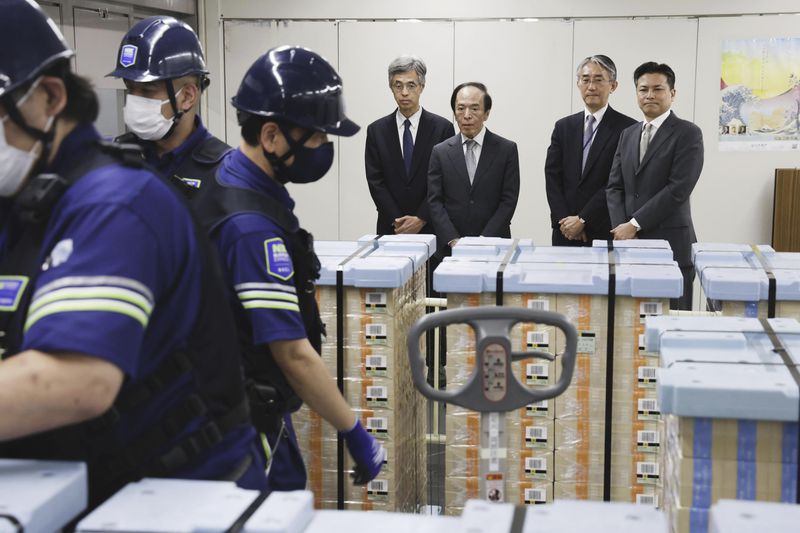 Bank of Japan Governor Kazuo Ueda, center, looks on as new banknotes are being delivered, at the BOJ headquarters in Tokyo, Japan, Wednesday, July 3, 2024. (Japan Pool/Kyodo News via AP)