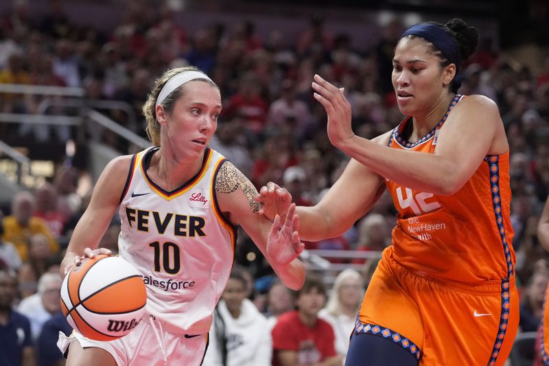 Indiana Fever guard Lexie Hull (10) drives on Connecticut Sun forward Brionna Jones (42) in the second half of a WNBA basketball game in Indianapolis, Wednesday, Aug. 28, 2024. (AP Photo/Michael Conroy)