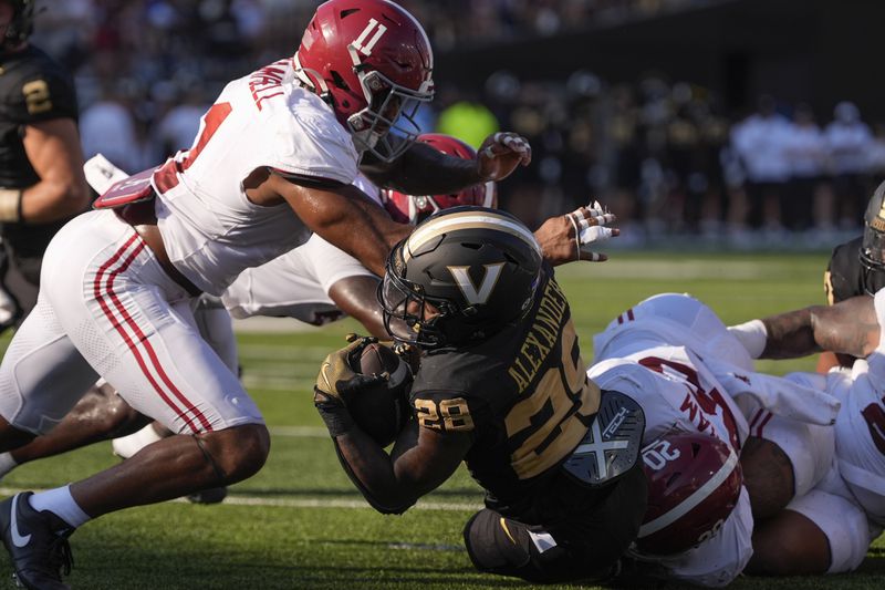 Vanderbilt running back Sedrick Alexander (28) is stopped short to the end zone by Alabama linebacker Jihaad Campbell (11) and defensive lineman Jah-Marien Latham (20) during the first half of an NCAA college football game Saturday, Oct. 5, 2024, in Nashville, Tenn. (AP Photo/George Walker IV)