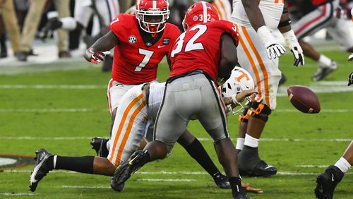 Georgia linebacker Monty Rice (32) strips the ball from Tennessee quarterback Jarrett Guarantano in the pocket during the second half Saturday, Oct. 10, 2020, at Sanford Stadium in Athens. Georgia won 44-21. JOHN AMIS FOR THE ATLANTA JOURNAL- CONSTITUTION