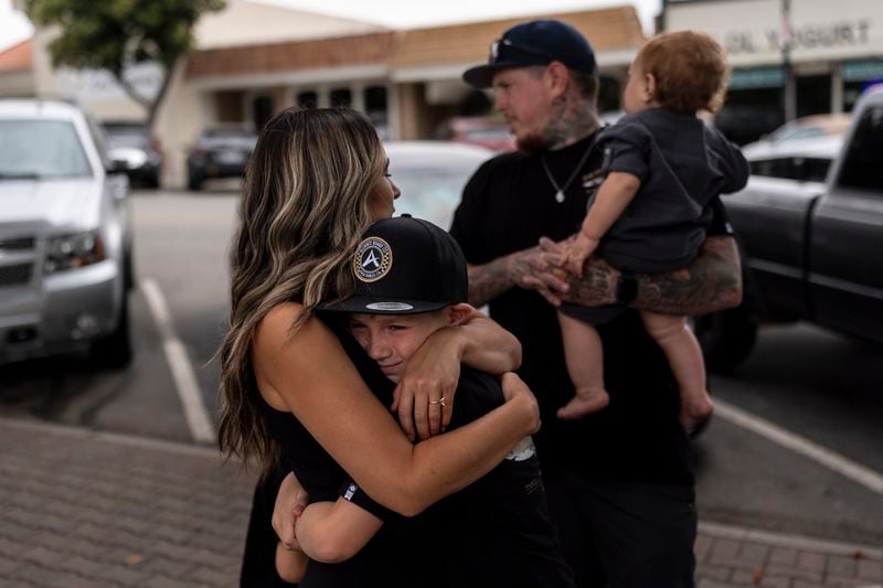 Mikayla Brown, left, comforts her son, Jax, as they stand in front of a park bench dedicated to her son, Elijah Ott, who died of a fentanyl overdose at 15, in Paso Robles, Calif., Friday, Aug. 2, 2024. (AP Photo/Jae C. Hong)