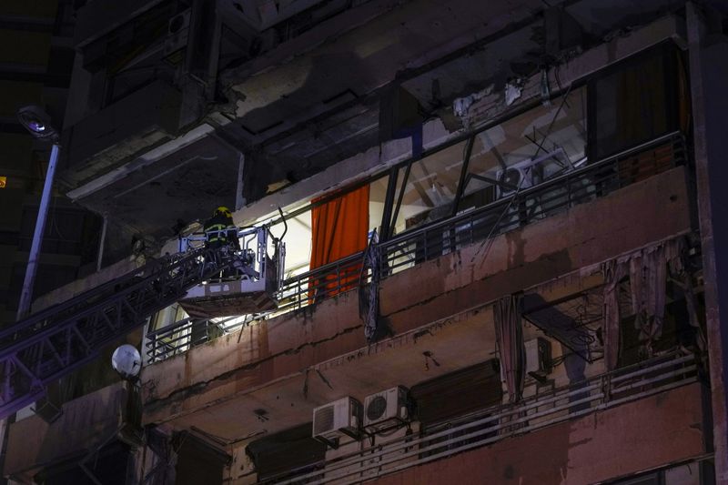 A fire engine ladder extends up a building that was hit in an apparent Israeli airstrike, in central Beirut, Lebanon, early Monday, Sept. 30, 2024. (AP Photo/Bilal Hussein)