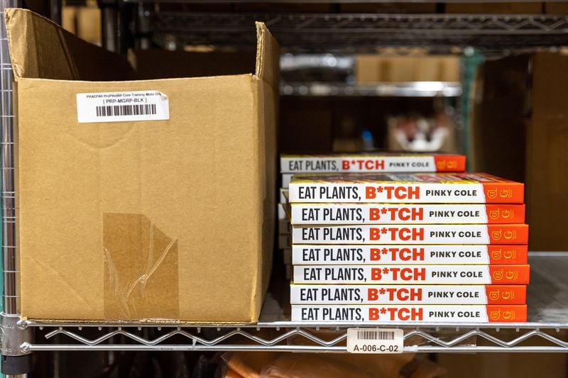 Books by Slutty Vegan founder Pinky Cole are seen at the warehouse of ECOMSPACES in Atlanta on Friday, Dec. 8, 2023. (Arvin Temkar / arvin.temkar@ajc.com)