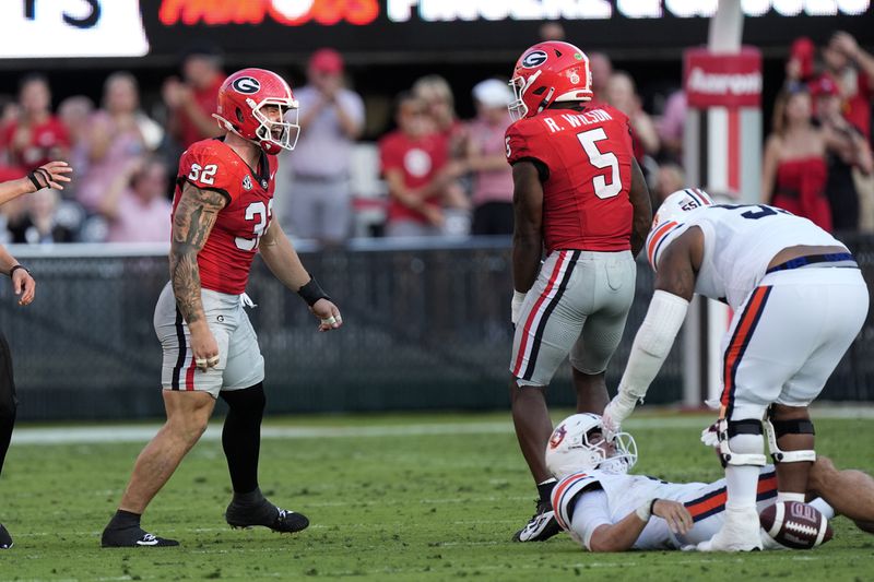 Georgia linebackers Chaz Chambliss (32) and Raylen Wilson (5) reacts after Georgia sacked Auburn quarterback Payton Thorne, right, in the second half of an NCAA college football game Saturday, Oct. 5, 2024, in Athens, Ga. (AP Photo/John Bazemore)