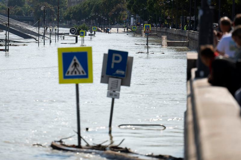 People watch the Danube river as it floods its banks, central Budapest, Hungary, Thursday, Sept. 19, 2024. (AP Photo/Denes Erdos)