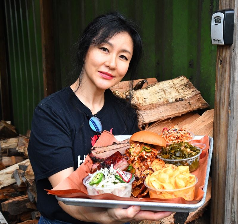 Jiyeon Lee of Heirloom Market BBQ holds a sampler platter that showcases the marriage of Korean flavors with Southern barbecue. Chris Hunt for The Atlanta Journal-Constitution 