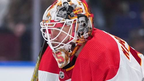 FILE - Artwork of Johnny Cash adorns the mask of Calgary Flames goalie Jacob Markstrom as he watches the action during the second period of an NHL hockey game against the Vancouver Canucks in Vancouver, British Columbia, March 23, 2024. The New Jersey Devils have agreed to acquire Markstrom in a trade with the Flames, a person with knowledge of the deal tells The Associated Press. It was not immediately clear what they were giving up. The Devils have been looking for a goalie and targeting Markstrom for quite some time. (Darryl Dyck/The Canadian Press via AP, file)
