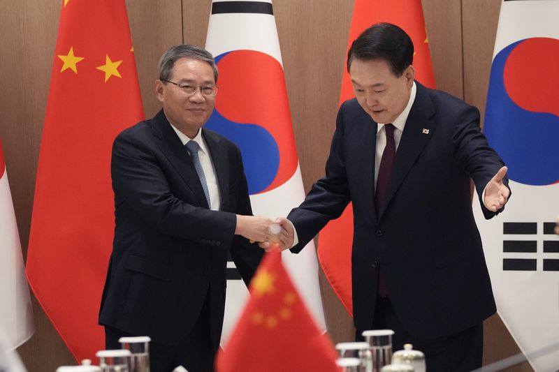 South Korean President Yoon Suk Yeol, right, greets Chinese Premier Li Qiang during a meeting at the Presidential Office in Seoul, South Korea, Sunday, May 26, 2024. (AP Photo/Ahn Young-joon, Pool)