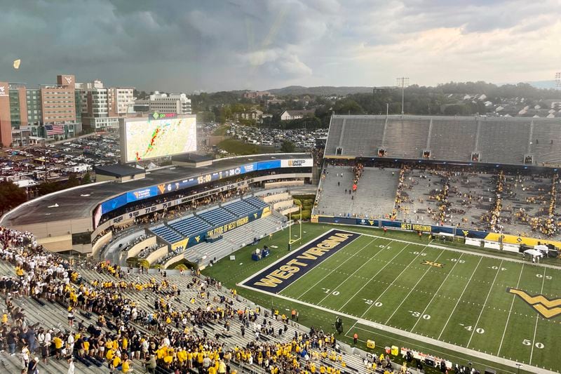 Storm clouds are shown over the stadium at halftime Saturday, Aug. 31, 2024, at the game between No. 8 Penn State and West Virginia in Morgantown, W.Va. Lightning forced the second half of the game to be delayed for several hours. (AP Photo/John Raby)