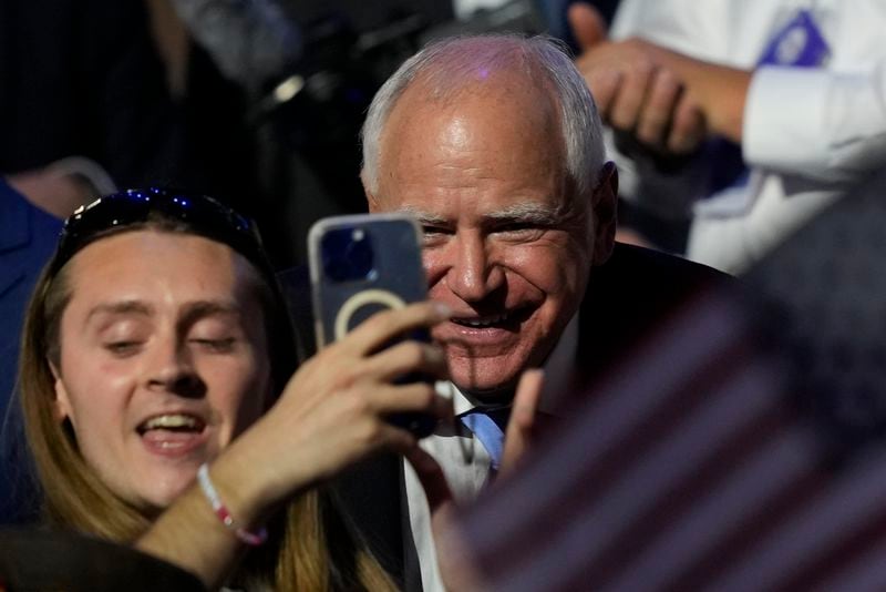 Democratic vice presidential nominee Minnesota Gov. Tim Walz has a picture taken during the Democratic National Convention Thursday, Aug. 22, 2024, in Chicago. (AP Photo/Matt Rourke)