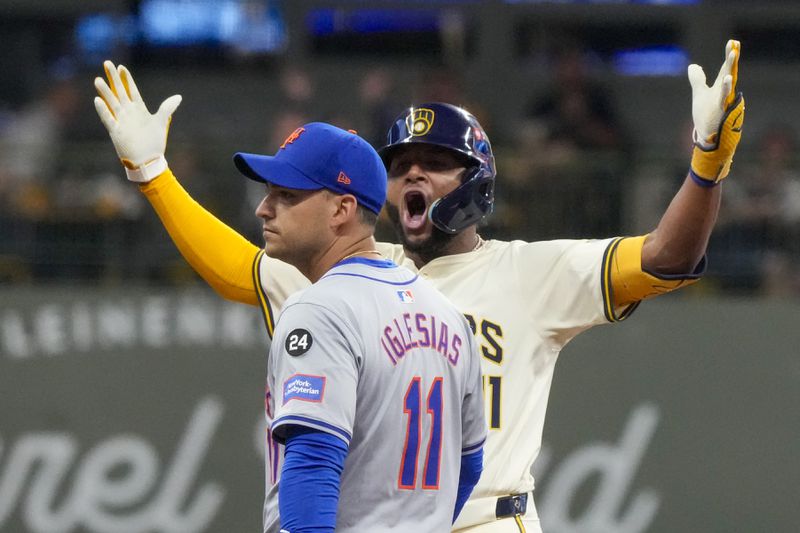 Milwaukee Brewers' Jackson Chourio reacts in front of New York Mets' Jose Iglesias after hitting an RBI double during the fourth inning of Game 2 of a National League wild card baseball game Tuesday, Oct. 1, 2024, in Milwaukee. (AP Photo/Morry Gash)