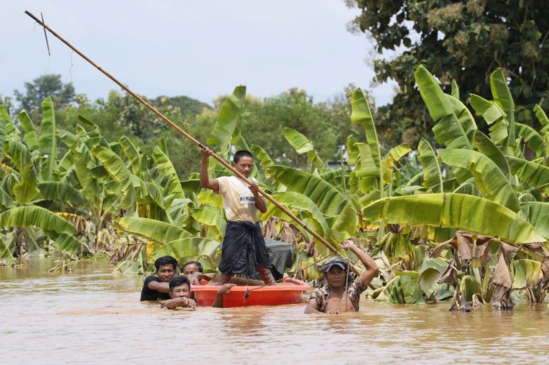 Local residents travel by small boat on a flooded road in Naypyitaw, Myanmar, Saturday, Sept. 14, 2024. (AP Photo/Aung Shine Oo)