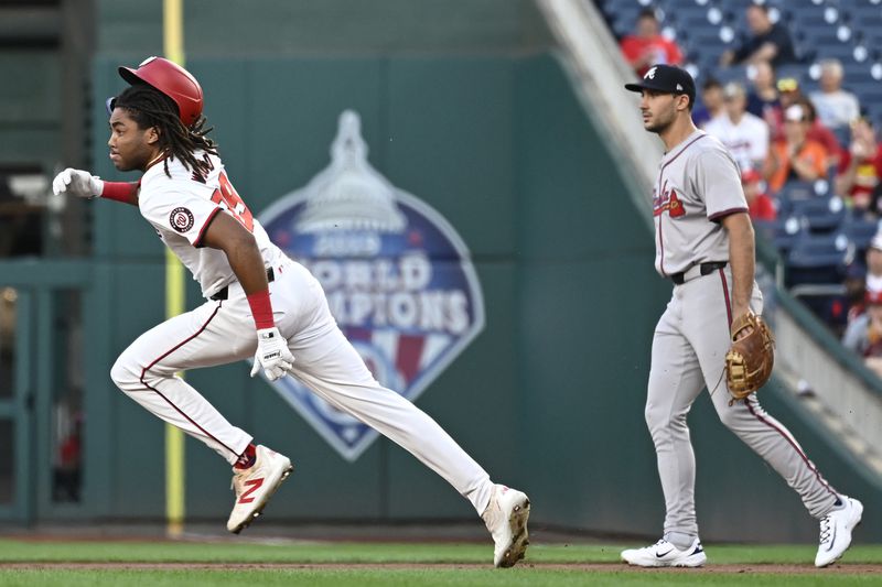 Washington Nationals' James Wood, left, runs past Atlanta Braves first baseman Matt Olson on a double during the first inning of a baseball game, Tuesday, Sept. 10, 2024, in Washington. (AP Photo/John McDonnell)