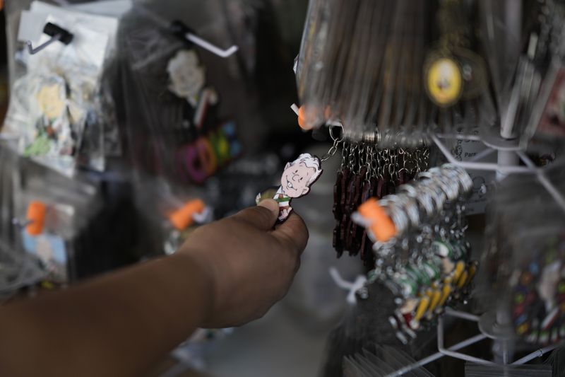 FILE - A shopper looks at a keychain of Mexican President Andrés Manuel López Obrador for sale outside the presidential palace in Mexico City, March 14, 2024. (AP Photo/Eduardo Verdugo, File)