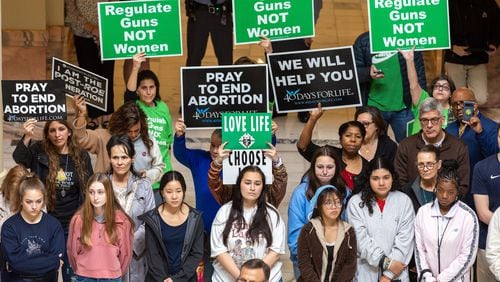 Activists who support abortion rights and abortion opponents hold signs expressing their views at an anti-abortion rally at the Georgia Capitol in February 2023. (Arvin Temkar/AJC)