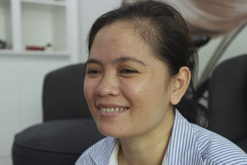 Chhim Sithar, president of the Labor Rights Supported Union of Khmer Employees of NagaWorld, smiles as she meets her staff members in her sister's home at the outskirts of Phnom Penh Cambodia, Monday, Sept. 16, 2024, after the prominent union leader freed from prison on Monday after serving time for her part in a strike against the country’s biggest casino. (AP Photo/Heng Sinith)