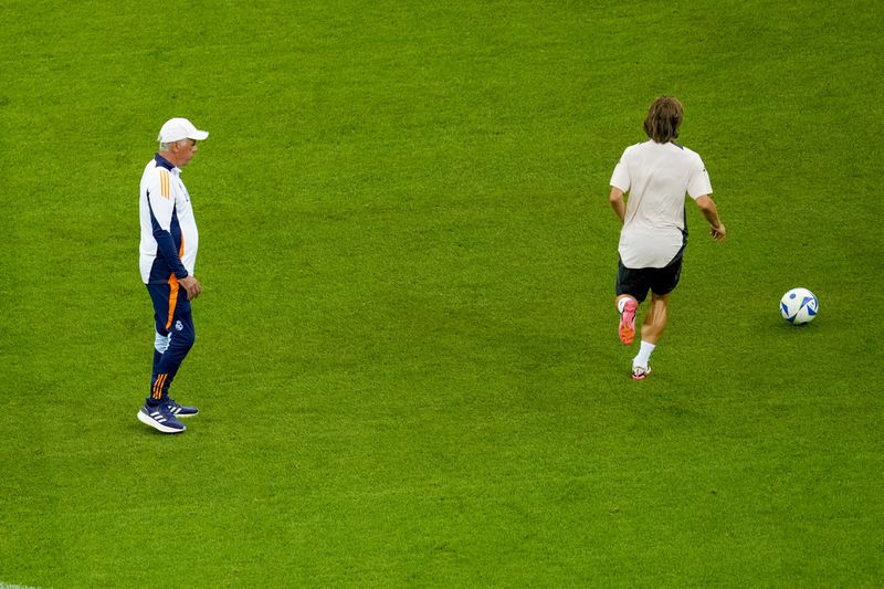 Real Madrid's head coach Carlo Ancelotti, left, looks at Real Madrid's Luka Modric during a training session ahead of the UEFA Super Cup Final soccer match between Real Madrid and Atalanta at the Narodowy stadium in Warsaw, Poland, Tuesday, Aug. 13, 2024. (AP Photo/Darko Vojinovic)