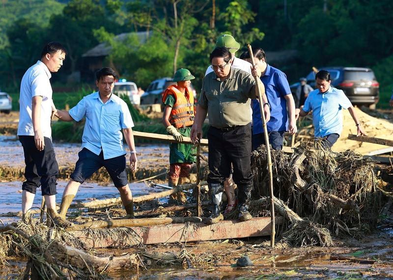 Vietnam's Prime Minister Pham Minh Chinh, foreground right, visits as rescue work is underway after a flash flood buries a hamlet in mud and debris in the aftermath of Typhoon Yagi in Lao Cai province, Vietnam Thursday, Sept. 12, 2024 (Duong Van Giang/VNA via AP)