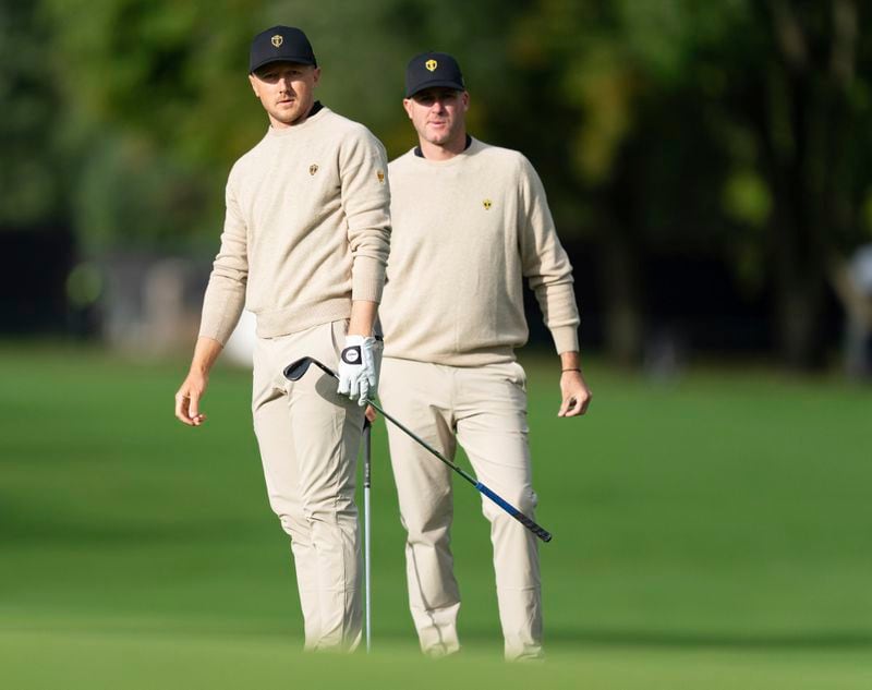 International team members Mackenzie Hughes, left, and Taylor Pendrith, of Canada, watch a shot on the second hole during practice at the Presidents Cup golf tournament at Royal Montreal Golf Club in Montreal, Tuesday, Sept. 24, 2024. (Christinne Muschi/The Canadian Press via AP)