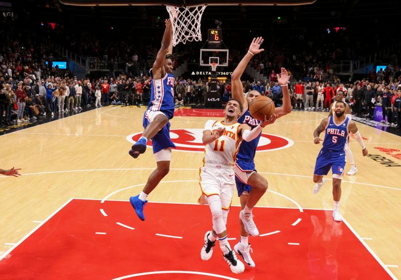 Atlanta Hawks guard Trae Young (11) goes up for a layup against Philadelphia 76ers guard Tyrese Maxey (0) and Philadelphia 76ers forward Nicolas Batum (40) during the second half at State Farm Arena, Wednesday, January 10, 2024, in Atlanta. The Hawks won 139-132 in overtime.  (Jason Getz / Jason.Getz@ajc.com)