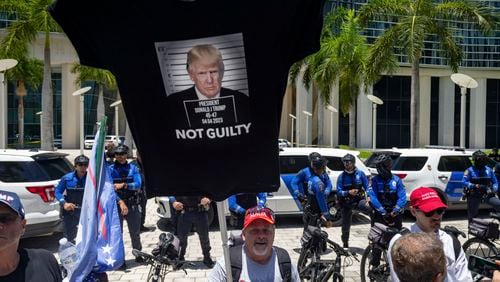 A supporter of former President Donald Trump carries a T-shirt as a banner outside the Wilkie D. Ferguson Jr. U.S. Courthouse in Miami, June 13, 2023. (Christian Monterrosa/The New York Times)