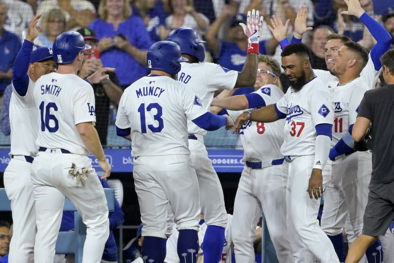 Los Angeles Dodgers Jason Heyward, back center, is congratulated by teammates at the dugout after hitting a pinch hit three-run home run in the eighth inning of a baseball game against the Seattle Mariners, Tuesday, Aug. 20, 2024, in Los Angeles. (AP Photo/Jayne-Kamin-Oncea)