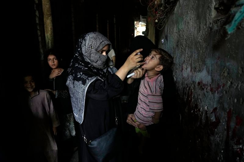 A health worker administers a polio vaccine to a child in a downtown area of Lahore, Pakistan, Monday, Sept. 9, 2024. (AP Photo/K.M. Chaudary)