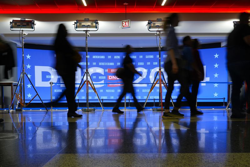 People walk past a display inside the United Center as preparations are made for next week's 2024 Democratic National Convention in Chicago, Friday, Aug. 16, 2024.(AP Photo/Pablo Martinez Monsivais)