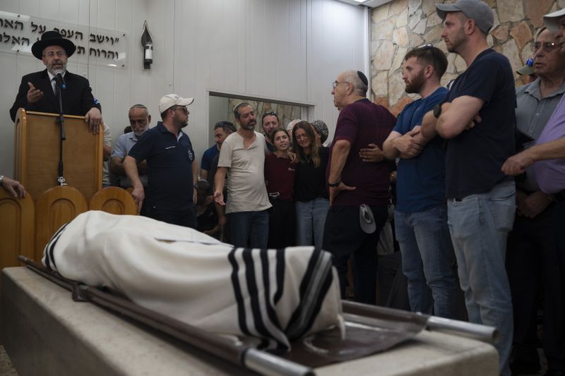 Relatives and friends of Yonatan Deutsch, who was killed in a drive-by shooting in the Israeli-occupied West Bank, mourn during his funeral at a cemetery in Jerusalem, Monday, Aug. 12, 2024. (AP Photo/Leo Correa)