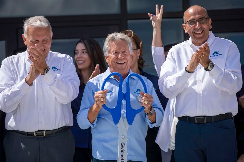 Mario Andretti, center, is joined by Eddie Hamann, right, Managing Partner of Andretti Indoor Karting & Games, family and other Andretti Indoor Karting & Games employees during the ribbon cutting ceremony for the grand opening of the Andretti Indoor Karting & Games in Buford Wednesday, June 23, 2021. (Alyssa Pointer / Alyssa.Pointer@ajc.com)

