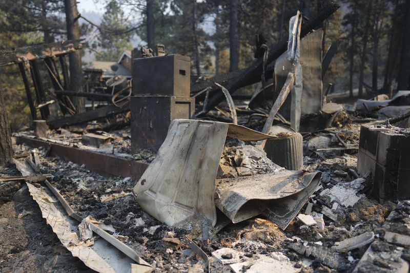 A fire-ravaged property is seen after the Bridge Fire swept through, Thursday, Sept. 12, 2024, in Wrightwood, Calif. (AP Photo/Eric Thayer)