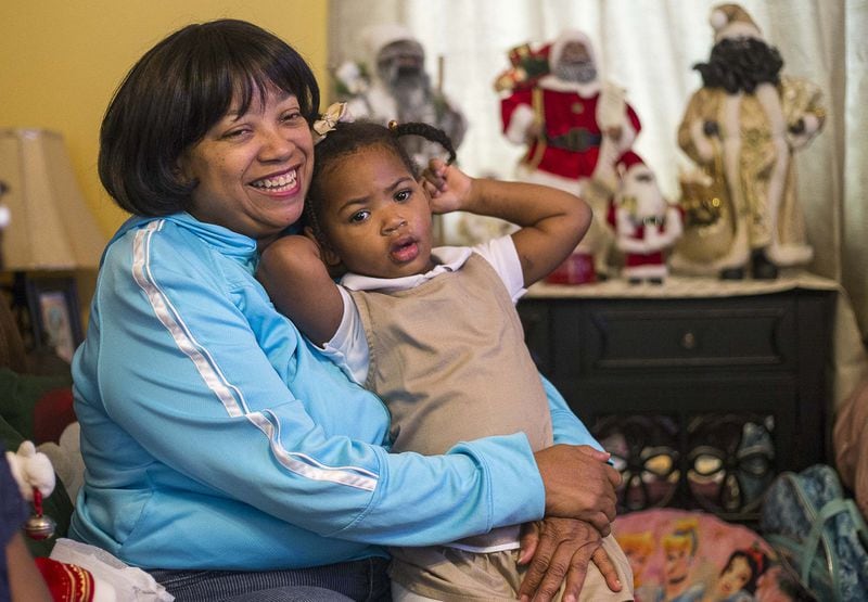 Priscilla Moses, 52, sits with her adopted daughter Karrigan, 2, at their residence in Decatur. Karrigan, who was born to a teenage mom, has been with the Moses sisters since she was 5 days old. They fostered her, then adopted her. 