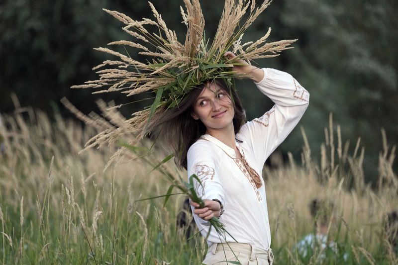 A young Ukrainian woman wearing an ear of grain braid attends a traditional Ukrainian celebration of Kupala Night, in Warsaw, Poland, on Saturday, June 22, 2024. Ukrainians in Warsaw jumped over a bonfire and floated braids to honor the vital powers of water and fire on the Vistula River bank Saturday night, as they celebrated their solstice tradition of Ivan Kupalo Night away from war-torn home. (AP Photo/Czarek Sokolowski)