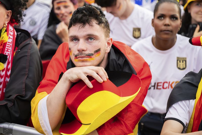 A Germany fan reacts in the fan zone at the Brandenburg Gate in Berlin, Germany, July 5, 2024 during the screening of a quarter final match between Germany and Spain at the Euro 2024 soccer tournament in Stuttgart, Germany. (Christoph Soeder/dpa via AP)
