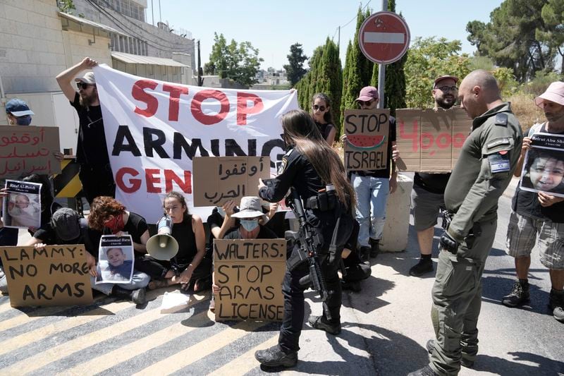 Police clear protesters, some chained, outside of the British consulate in east Jerusalem, to call on the U.K. to stop providing arms to Israel for its war in the Gaza Strip, during a visit by Foreign Secretary David Lammy and his French counterpart during internationally mediated cease-fire talks in Qatar, Friday, Aug. 16, 2024. (AP Photo/Mahmoud Illean)