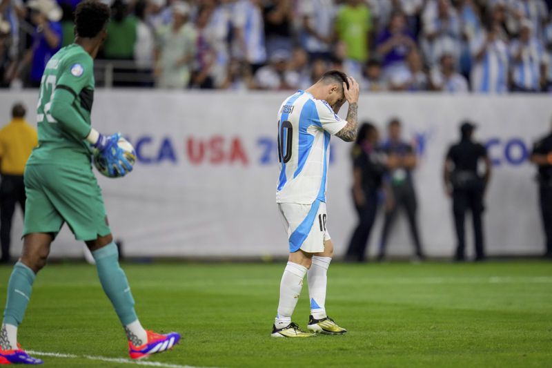 Argentina's Lionel Messi holds his head after missing to score in a penalty shootout against Ecuador in a Copa America quarterfinal soccer match in Houston, Thursday, July 4, 2024. (AP Photo/Julio Cortez)