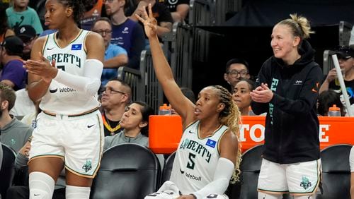 New York Liberty's Kennedy Burke, left, Kayla Thornton (5) and Courtney Vandersloot celebrate a 3-pointer by Liberty's Sabrina Ionescu during the second half of a WNBA basketball game against the Phoenix Mercury, Monday, Aug. 26, 2024, in Phoenix. (AP Photo/Ross D. Franklin)