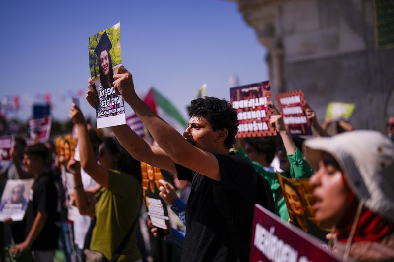 People hold up photographs of Aysenur Ezgi Eygi, 26 year-old Turkish-American activist killed by the Israeli military, as they shout slogans during a protest in her memory in Istanbul, Turkey, Saturday, Sept. 14, 2024. (AP Photo/Francisco Seco)