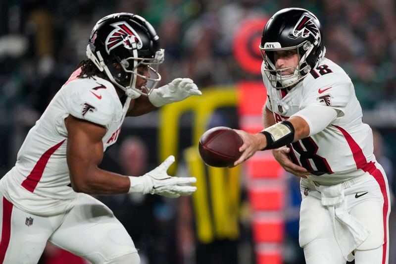 Atlanta Falcons quarterback Kirk Cousins (18) hands off to Falcons running back Bijan Robinson (7) during the first half of an NFL football game against the Philadelphia Eagles on Monday, Sept. 16, 2024, in Philadelphia. (AP Photo/Matt Rourke)