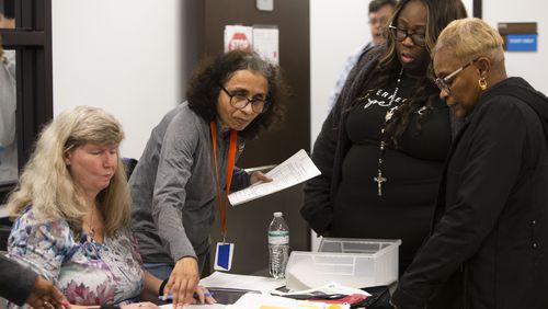 Election workers in Gwinnett County count votes delivered by poll managers in the U.S. Senate runoff election in December 2022, in Lawrenceville. CHRISTINA MATACOTTA FOR THE ATLANTA JOURNAL-CONSTITUTION.