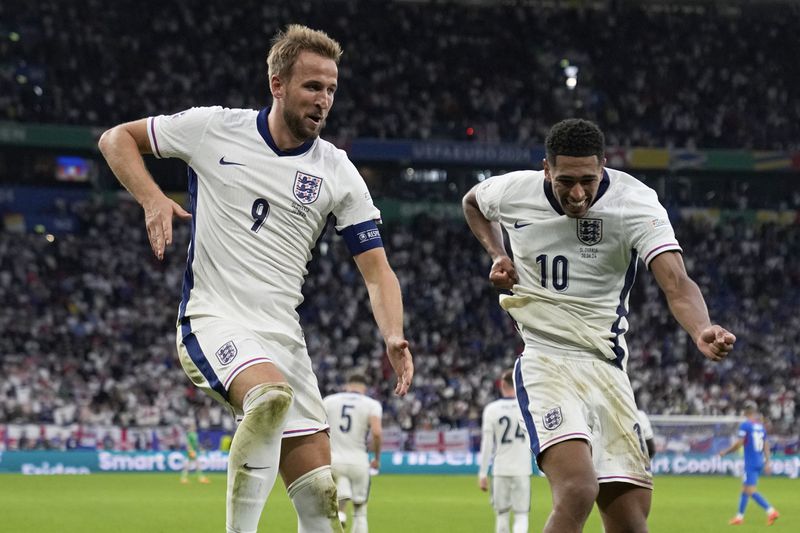 England's Harry Kane, left, celebrates with Jude Bellingham after scoring his side's second goal during a round of sixteen match between England and Slovakia at the Euro 2024 soccer tournament in Gelsenkirchen, Germany, Sunday, June 30, 2024. (AP Photo/Thanassis Stavrakis)