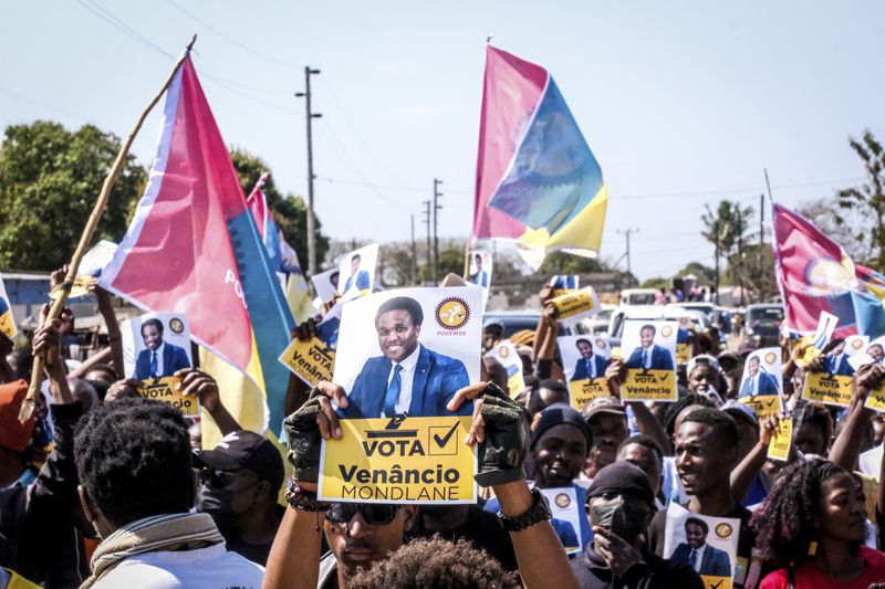 A poster of independent candidate Venacio Mondlane is held at an election rally on Sunday, Oct. 6, 2024 in Maputo ahead of elections in Mozambique. (AP Photo/Carlos Uqueio)