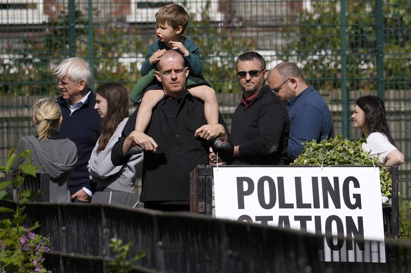 Voters queue at a polling station in London, Thursday, July 4, 2024. Voters in the U.K. are casting their ballots in a national election to choose the 650 lawmakers who will sit in Parliament for the next five years. Outgoing Prime Minister Rishi Sunak surprised his own party on May 22 when he called the election. (AP Photo/Vadim Ghirda)