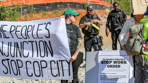 September 7, 2023 DeKalb County: Protesters gathered on Constitution Road (shown here) after five individuals were arrested Thursday morning, Sept. 7, 2023 at the site of Atlanta’s proposed public safety training center after chaining themselves to construction equipment in an effort to halt work. According to the Atlanta Police Department, the training center opponents broke into the construction site off Constitution Road around 9:30 a.m. Thursday. “Those 5 people have been taken into custody and we are working with the Georgia Bureau of Investigation regarding charges on these individuals,” the department said in a statement. About two dozen protesters also lined the site in unincorporated DeKalb County, east of Atlanta, in opposition to the 85-acre facility. They chanted “Cop City will never be built” as law enforcement officers amassed. The crowd called the effort “the people’s injunction” to halt construction. “We have tried to get justice in the courts, we have tried to get justice using our politicians, and unfortunately, they have betrayed and failed us,” said Mary Hooks, with the activist group Movement for Black Lives. “So when our government systems fail, that is when the people must stand up and take action.” The demonstration comes just days after more than 60 anti-training center activists were indicted on racketeering and other charges over the ongoing clash between the city and facility opponents. The indictment mainly focuses on the Defend the Atlanta Forest group, with prosecutors describing it as an “anti-government, anti-police, and anti-corporate extremist organization.” The indictment, handed up by a Fulton County grand jury, is being prosecuted by the Georgia Attorney General’s Office. “Anytime somebody puts their bodies on the line for the cause,” said Hooks, “it was worth the risk.” (John Spink / John.Spink@ajc.com)

