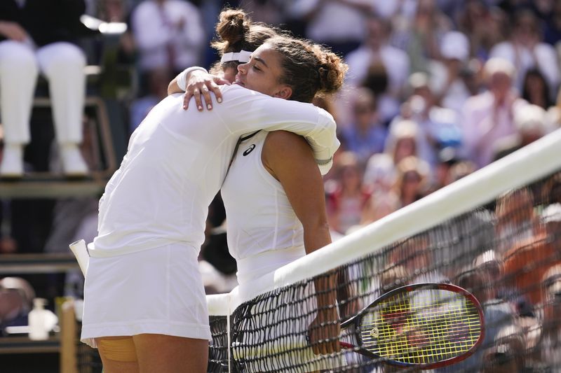 Barbora Krejcikova, left, of the Czech Republic is congratulated by Jasmine Paolini of Italy after winning the women's singles final at the Wimbledon tennis championships in London, Saturday, July 13, 2024. (AP Photo/Alberto Pezzali)