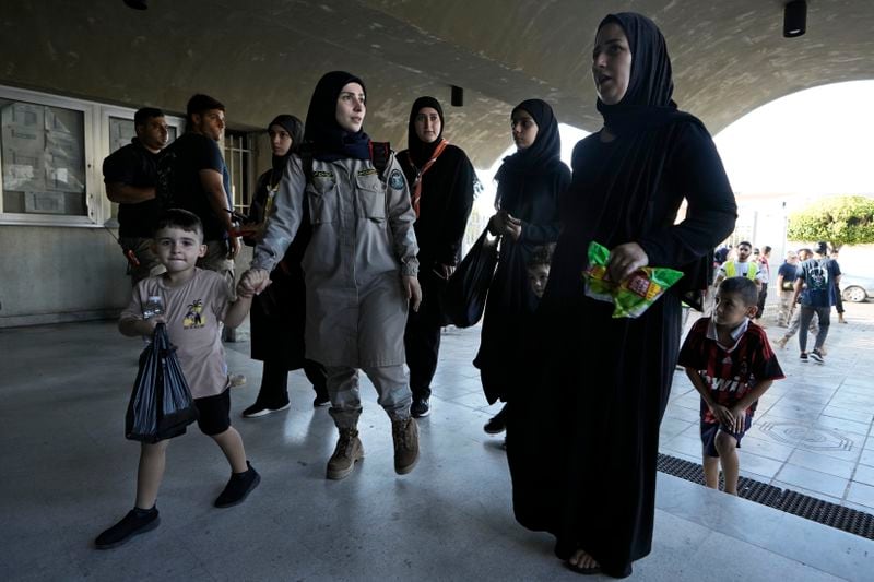 Women and children fleeing the Israeli airstrikes in the south, arrive at a school turned into a shelter in Beirut, Monday, Sept. 23, 2024. (AP Photo/Bilal Hussein)