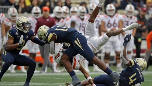 Virginia Tech wide receiver Tre Turner is upended by Georgia Tech linebacker Quez Jackson (4) in the second half of an NCAA college football game Saturday, Oct. 30, 2021, in Atlanta. (AP Photo/Ben Margot)